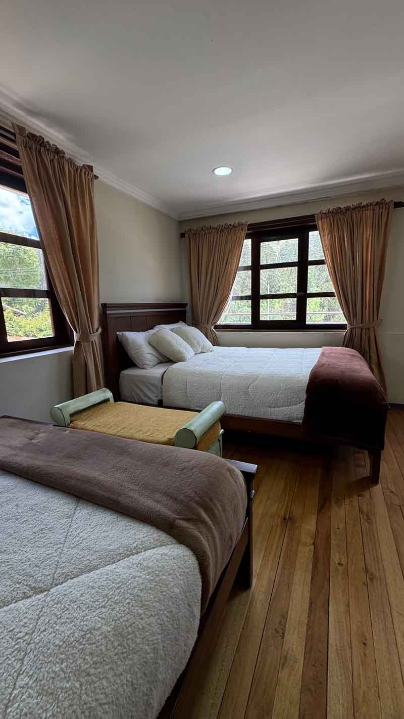 Habitación con dos camas y piso de madera