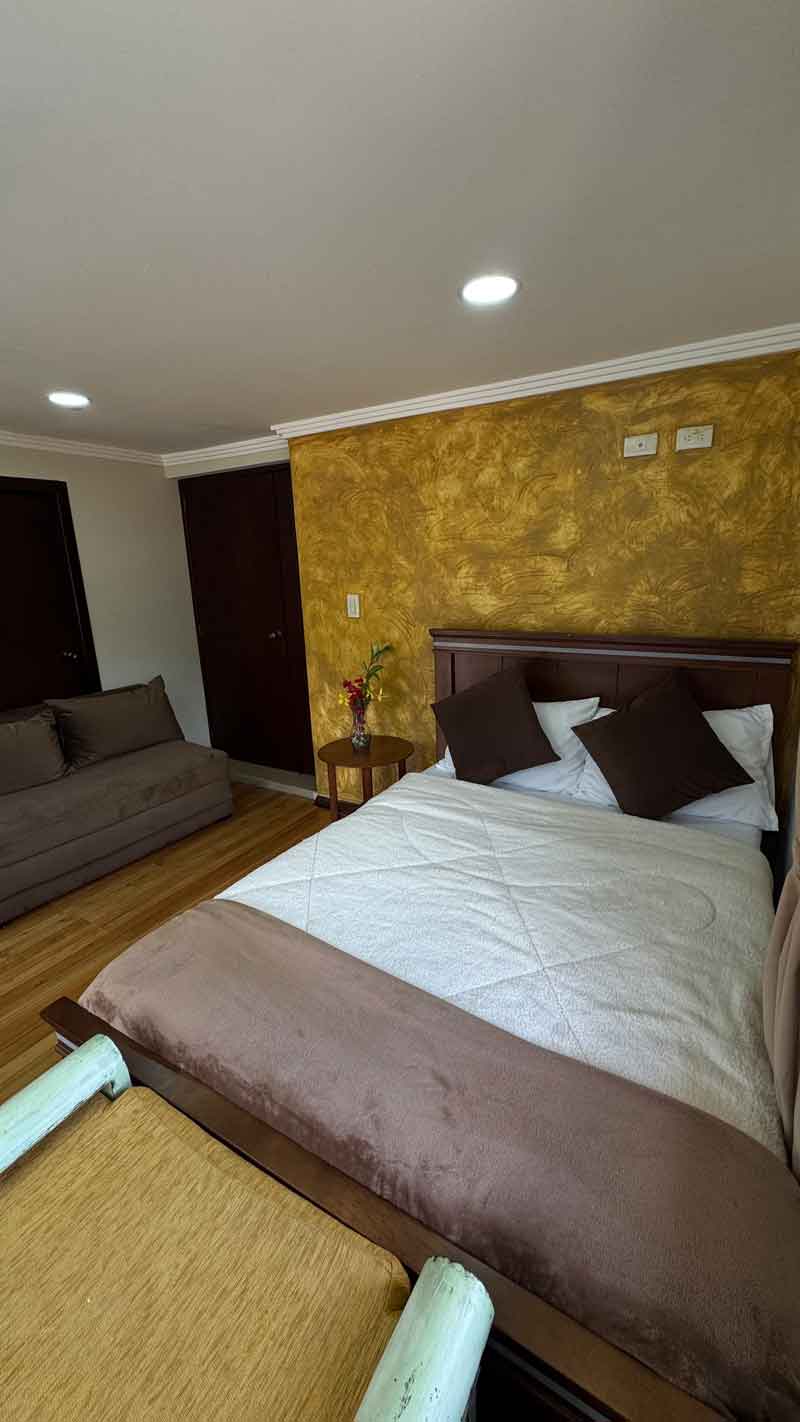 Habitación matrimonial con pared dorada